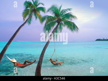 Couple hanging sous les palmiers de l'océan Indien aux Maldives Banque D'Images