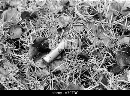 Shot gun couché cartouche jetée sur le terrain Banque D'Images