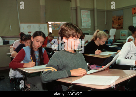 Des élèves du premier cycle du secondaire en prenant un test de sciences sociales en classe Banque D'Images