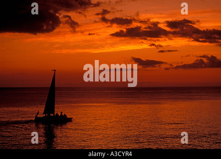 Voilier au coucher du soleil au large de la côte de Negril Jamaïque Banque D'Images