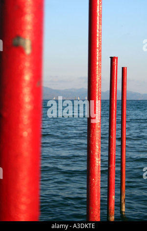 Poteaux de métal rouge sur l'eau de mer. Banque D'Images
