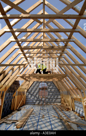 Un constructeur bois le toit d'arpentage d'une nouvelle maison en construction. Banque D'Images