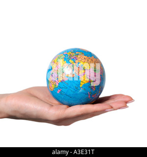Main de femme tendue avec un globe posé sur le repose sur un fond blanc.