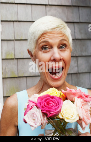 Portrait of a young woman holding Flowers dans un vase et à la surprise Banque D'Images