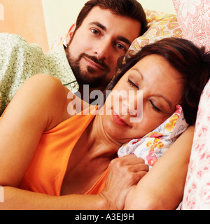 Close-up of a young woman sleeping with a young man lying derrière elle Banque D'Images