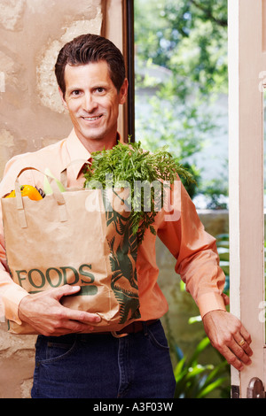 Portrait of a young man smiling and holding a Shopping bag Banque D'Images