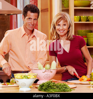 Portrait of a young woman cutting vegetables and smiling Banque D'Images