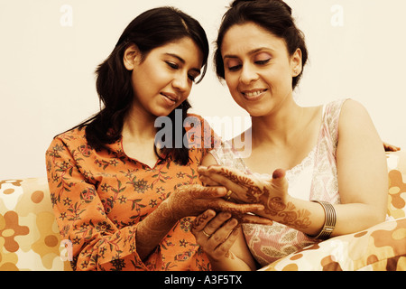 Deux femmes regardant leurs mains tatouées au henné Banque D'Images