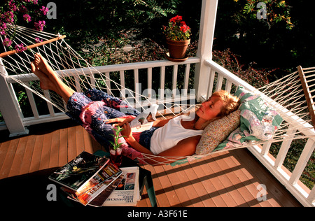 Woman ou de dormir dans un hamac sur un vieux porche dans le soleil Banque D'Images