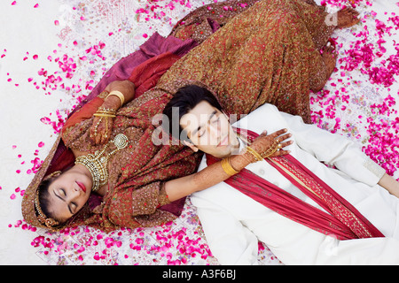 High angle view of a young couple dans des tenues de mariage avec traditionnels de dormir sur le lit Banque D'Images