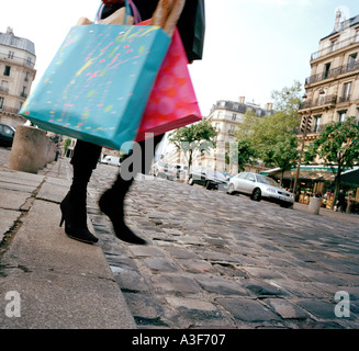 Femme en descendant de bordure avec des sacs de shopping dans la rue de Paris Banque D'Images