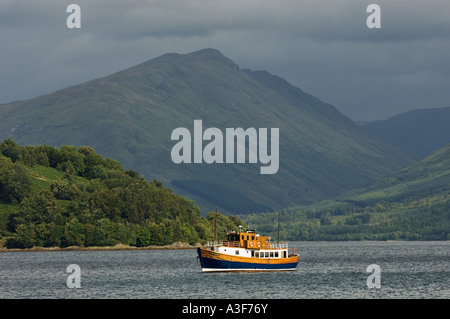 Faisceau de lumière éclairant bateau au mouillage sur le Loch Fyne avec approche de l'orage dans l'arrière-plan l'Écosse Inveraray Banque D'Images