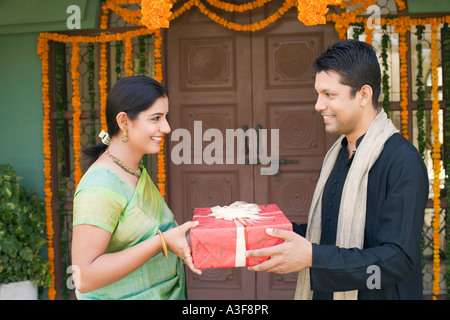 Portrait of a Mid adult man giving une boîte-cadeau d'une jeune femme Banque D'Images
