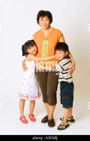 Portrait of a young woman standing avec son petit-fils et une petite-fille Banque D'Images