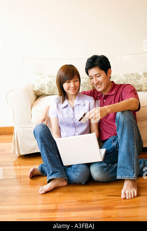 Jeune couple shopping online avec une carte de crédit Banque D'Images