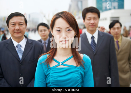 Portrait of a young woman standing avec quatre hommes d Banque D'Images