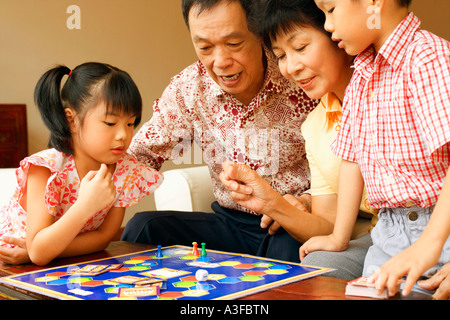 Close-up d'une fille et un garçon joue une partie avec leurs grands-parents Banque D'Images