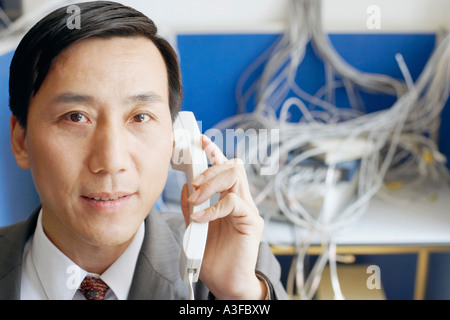 Portrait d'un homme d'affaires à l'aide d'un téléphone dans une salle de serveur Banque D'Images