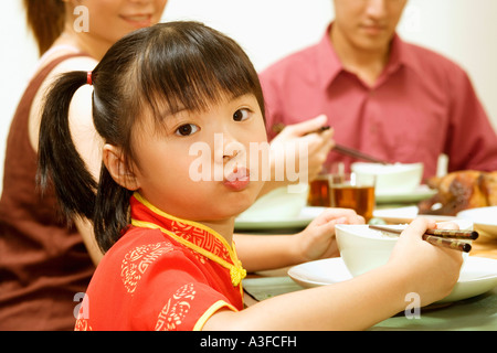Portrait of a Girl eating with chopsticks Banque D'Images