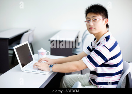 Portrait d'un jeune homme à l'aide d'un ordinateur portable Banque D'Images