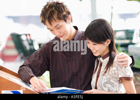 Close-up of a young woman reading a book and smiling Banque D'Images