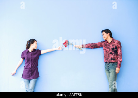 Jeune homme donnant des roses à une jeune femme Banque D'Images