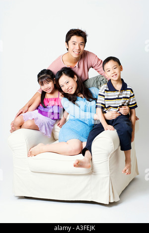 Portrait of a Mid adult man et une jeune femme assise dans un fauteuil avec leur fils et fille Banque D'Images