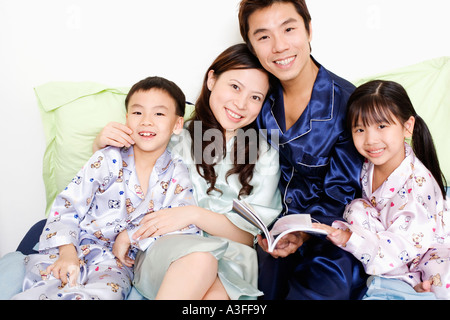 Portrait d'un garçon et une fille souriant de leurs parents sur le lit