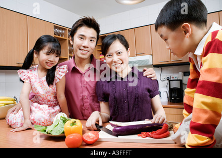 Portrait d'un couple avec leurs enfants dans une cuisine domestique Banque D'Images