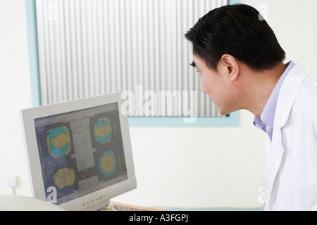 Portrait d'un médecin homme regardant un écran d'ordinateur Banque D'Images