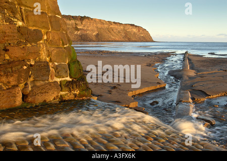 Robin Hoods Bay à la base de la chaussée à la recherche vers le Nord joue également connu sous le nom de Ness Point montrant débit sortant Banque D'Images