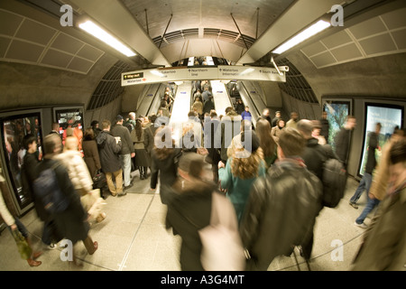 Les frontaliers et les passagers sortant de la station de métro dans les escaliers mécaniques Banque D'Images