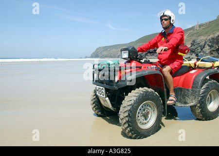 Plage de la RNLI sur Lifegard patrouille quad à marée basse Chapelle Cornwall Porth UK Banque D'Images