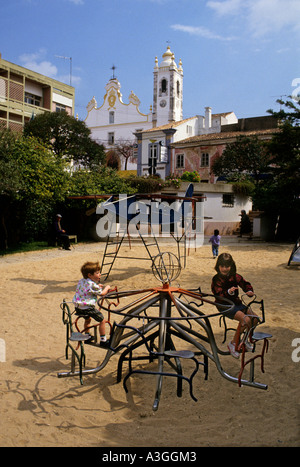 Garçon et fille sur le rond-point en aire de Portimao Algarve Portugal Banque D'Images