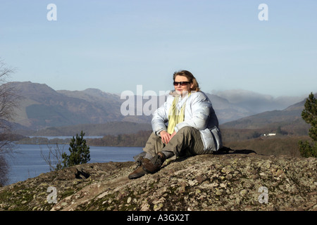 Un touriste admire la vue sur le Loch Lomond à partir d'une colline au-dessus de l'Ecosse Balmaha Banque D'Images