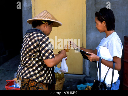 L'achat de collations locales girl vendeur de rue locale Kuta Bali Indonésie Banque D'Images