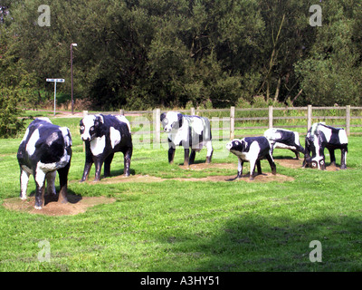 Groupe de vaches fransiennes noires et blanches dans une sculpture en béton dans un parc à Milton Keynes une nouvelle ville de 1967 dans Buckinghamshire Angleterre Royaume-Uni Banque D'Images