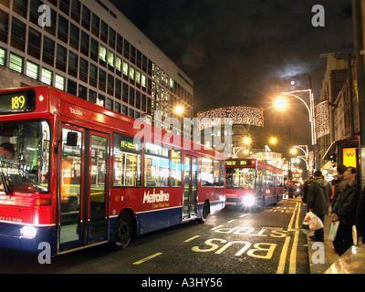 Les bus et les décorations lumineuses dans Oxford Street Londres juste avant le jour de Noël Banque D'Images