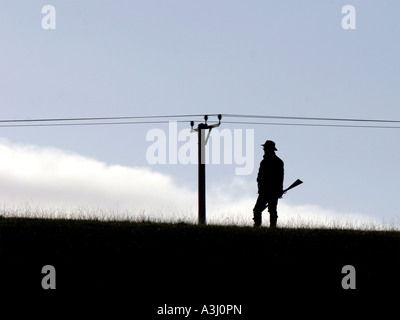 Silhouette de hunter avec fusil sur horizon Banque D'Images