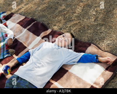 Boy lying on blanket Banque D'Images