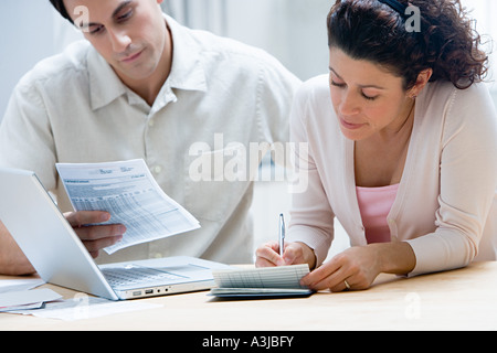 Couple faire le tri des finances du foyer Banque D'Images