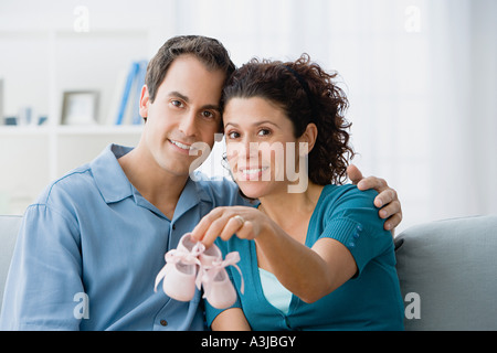 Couple tenant une paire de chaussures de bébé Banque D'Images