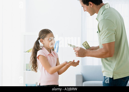 Père fille donnant de l'argent de poche Banque D'Images