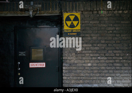 Vue d'un surintendant s porte et fallout shelter nucléaire signer dans la cour d'un immeuble en briques à New York Banque D'Images