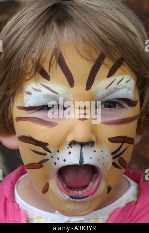 Happy little girl avec Tiger visage peint Banque D'Images