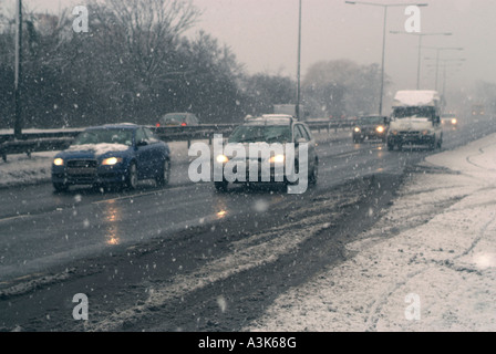 Les voitures roulent le long de dans De la neige avec de la glace et de la neige sur une artère. 2018122235120 Banque D'Images