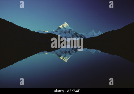 Le sommet de l'Ama Dablam reflétée dans un lac glaciaire de haute altitude région Everest Solu Khumbu Népal Himalaya Banque D'Images