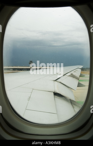 Voir le passager d'un avion de la fenêtre ronde's wing sur la piste de l'Aéroport Barajas de Madrid Espagne Europe Banque D'Images