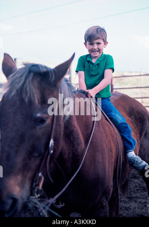 Little Boy riding horse sur corral Banque D'Images