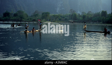 Les hommes à bord de canots éperviers de prendre du poisson en fin d'après-midi, sur la rivière Nam Xong, Vang Vieng, Laos. DN28 Banque D'Images